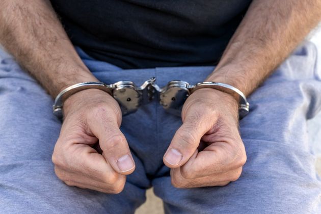 Close-up of the hands of an arrested and handcuffed man.