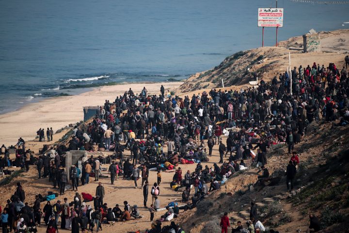 Displaced Palestinians gather with their belongings near a roadblock on the al Rashid Street, as they wait to return to their homes in the northern part of the Gaza Strip, Sunday, Jan. 26, 2025.