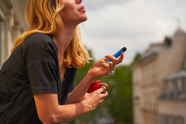 Woman with vape on balcony