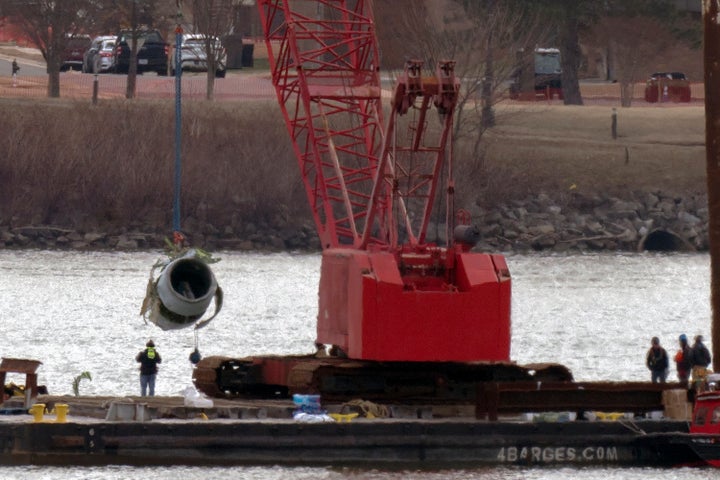 Rescue and salvage crews pull up a plane engine as cranes work near the wreckage of an American Airlines jet in the Potomac river on Monday.