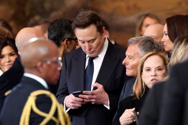 Elon Musk uses his cell phone after the 60th Presidential Inauguration in the Rotunda of the U.S. Capitol in Washington, Monday, Jan. 20, 2025.