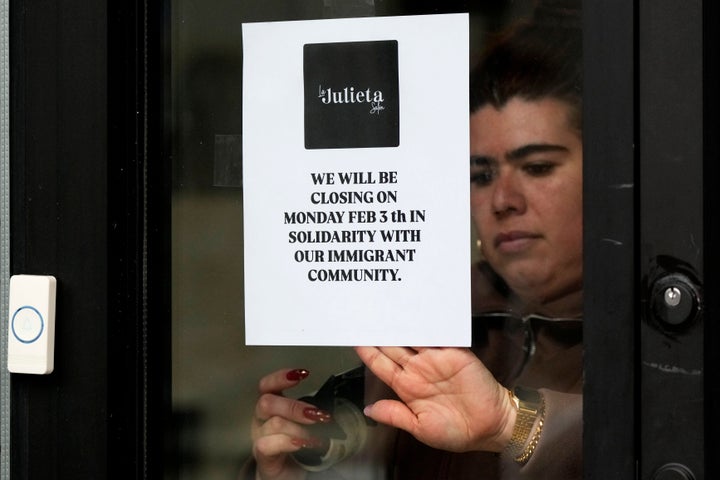 Andrea Toro, owner of La Julieta Salon, tapes a closure sign on her store in the Pilsen neighborhood of Chicago, to stand with immigrants, on Monday.