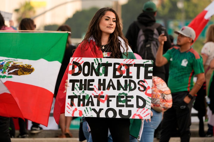 A demonstrator holds a sign that reads "don't bite the hands that feed you" during a rally for immigrant rights Monday in Los Angeles.