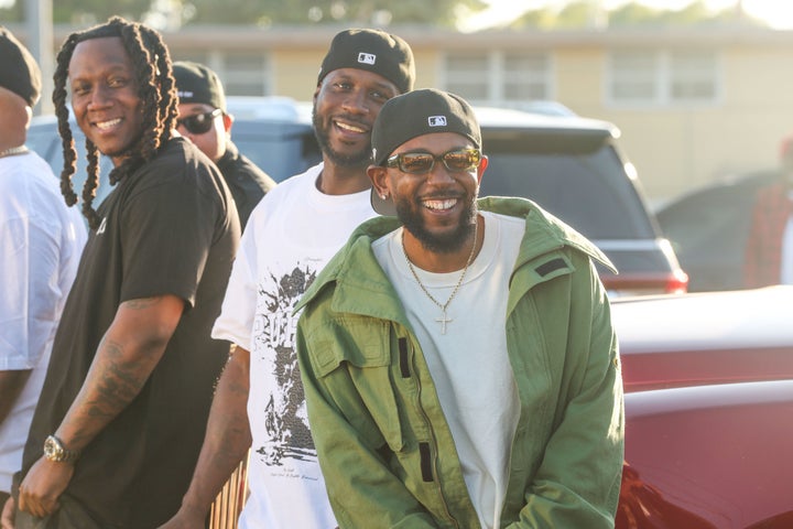 Kendrick Lamar smiles alongside Jay Rock, center, in between filming the music video for "Not Like Us" on June 22, 2024 in Watts, California.