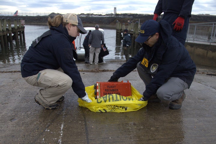 National Transportation Safety Board investigators examine a flight data recorder recovered from the wreckage of a midair collision between an Army Black Hawk helicopter and an American Airlines jet on Jan. 29 near Ronald Reagan Washington National Airport in Washington, D.C.