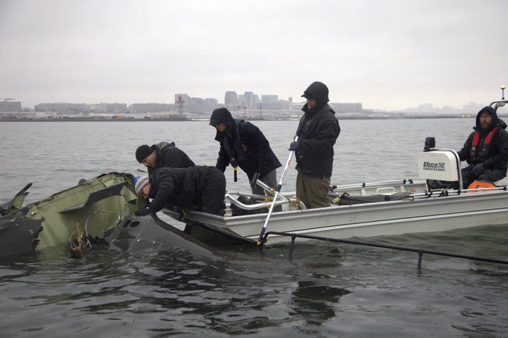 NTSB investigators and members of the salvage crew recover wreckage from the Army Black Hawk helicopter.