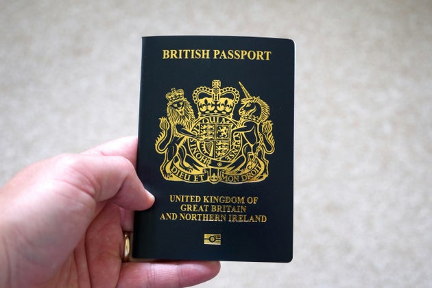 Hand holding UK passport