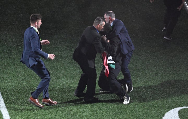 The man was tackled by security and dragged off the field. 
