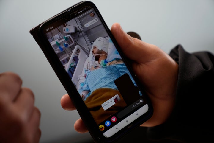 Mohammed Shula shows a picture of his hospitalized son, Yazan, while inside a relative's house where he and his wife have taken refuge at the West Bank village of Kafr al-Labad, on Monday, Feb. 10, 2025.