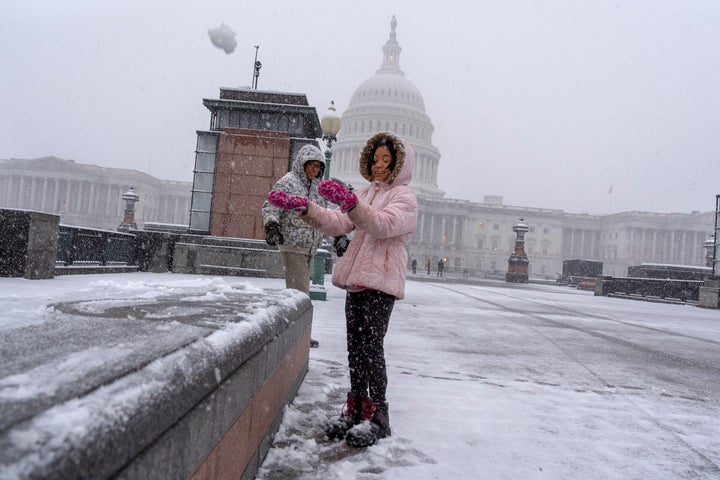 Hawwa Laut Jasindo, 7, who is visiting with family from Indonesia, throws a snowball in the air by the Capitol, on Feb. 11, 2025, during a snowstorm in Washington.