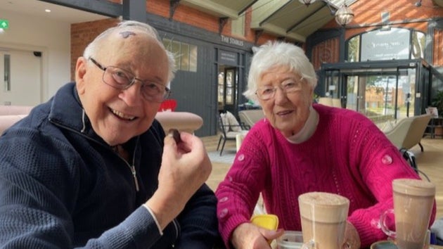 Norman and Bettie, both 91, smiling over coffee