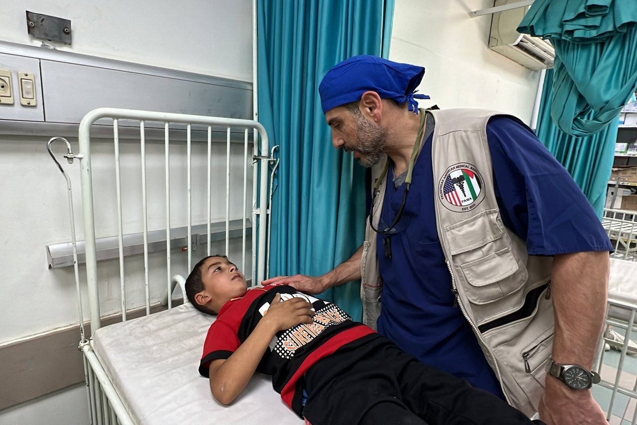 Dr. Adam Hamawy, an American plastic surgeon volunteering at European Hospital, checks on an injured Palestinian child in Khan Younis, Gaza on May 17, 2024.