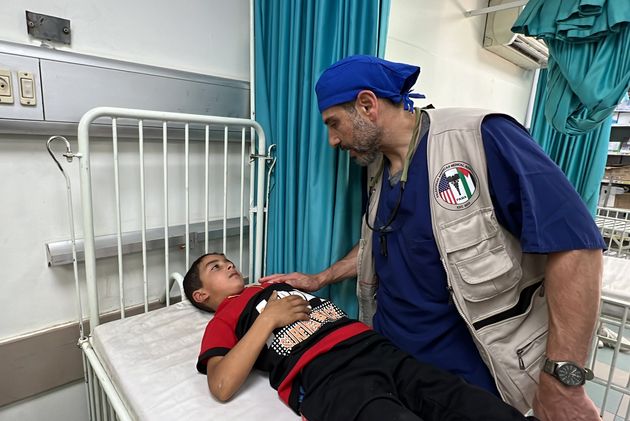 Dr. Adam Hamawy, an American plastic surgeon volunteering at European Hospital, checks on an injured Palestinian child in Khan Younis, Gaza on May 17, 2024.