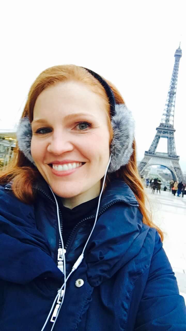 The author in Paris on her first-ever solo trip, celebrating her 35th birthday with the Eiffel Tower behind her.