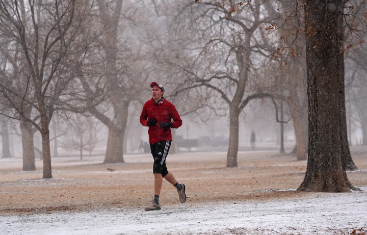 A runner contends with snow while circling Washington Park as a winter storm sweeps over Colorado's Front Range communities Saturday, Feb. 15, 2025, in Denver. (AP Photo/David Zalubowski)