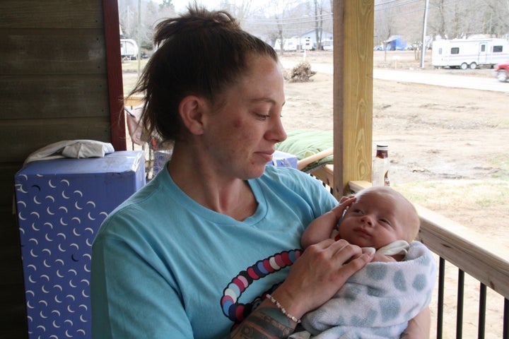 Hurricane Helene survivor Emily Russell holds her infant son on her front porch, which was built by volunteers, in Swannanoa, North Carolina, on Thursday, Feb. 6, 2025.