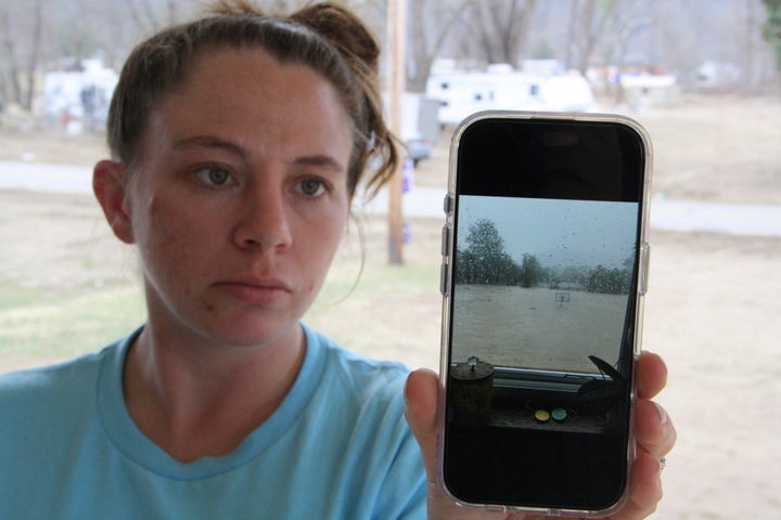 Emily Russell holds up her phone to show a photo of the flooding outside her home during Hurricane Helene, in Swannanoa, North Carolina, on Thursday, Feb. 6, 2025.