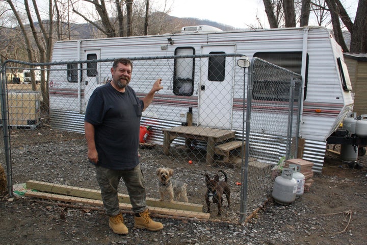 Hurricane Helene survivor Danny Bailey, 61, stands in front of the trailer he lives in with his dogs in Swannanoa, North Carolina, on Thursday, Feb. 6, 2025.