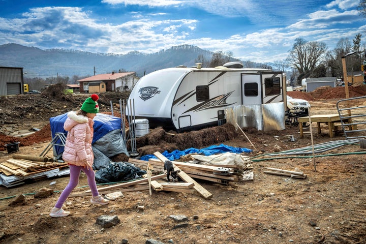 Addisun Cole, 8, plays with her grandmother Vickie Revis' cat outside a trailer, where Revis is living after Hurricane Helene destroyed her home in Swannanoa, North Carolina, on Wednesday, Feb. 5, 2025.