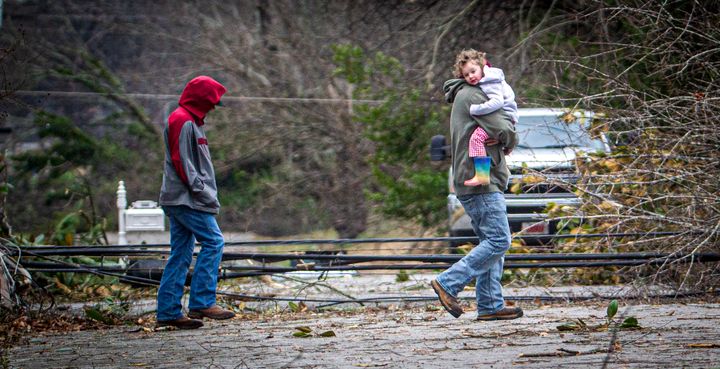 A man carries a little girl to a truck from a house amidst debris from a storm in east Tuscumbia, Ala., Sunday, Feb. 16, 2025. (Dan Busey/The TimesDaily via AP)