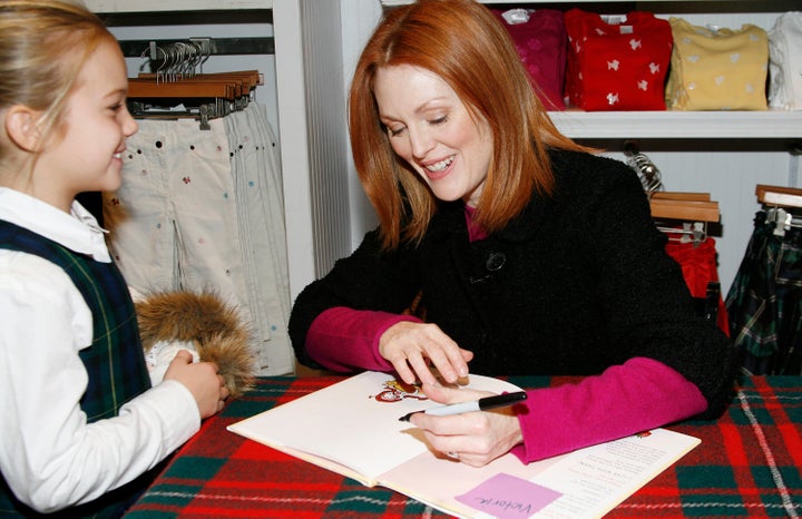 Moore signing a copy of her book, "Freckleface Strawberry," in 2007 for a happy child in New York City. She said that the book has been "banned" by the Department of Defense.