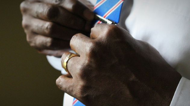 Close-up of a person's knuckles as they tie their tie