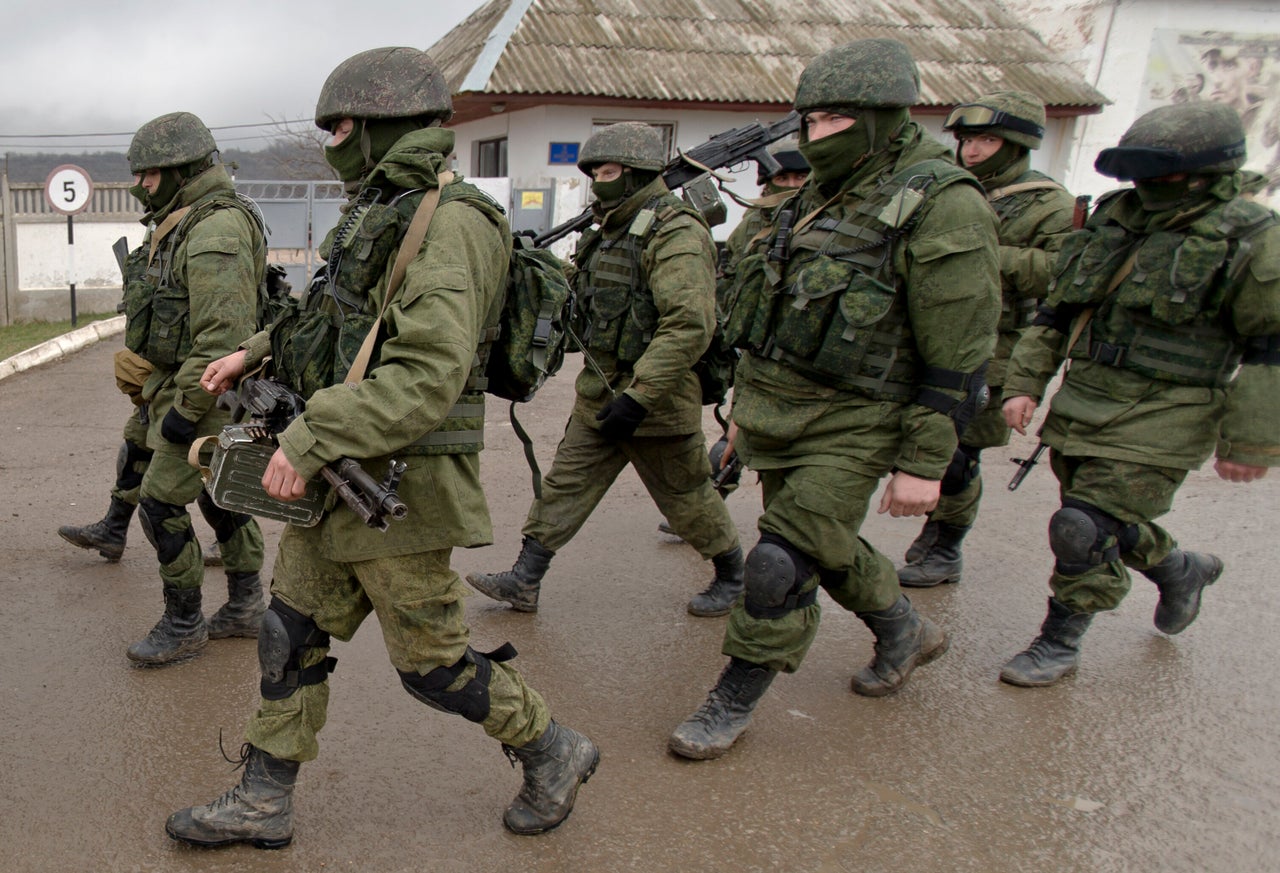 Pro-Russian soldiers march outside an Ukrainian military base in Perevalne, Crimea, Thursday, March 20, 2014. 