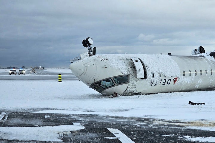 The wreckage of a Delta Air Lines jet rests upside down Tuesday after it burst into flames and flipped a day earlier at Toronto Pearson International Airport.