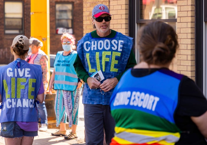 An anti-abortion protester attempts to talk to a clinic escort on July 7, 2022, outside of an abortion clinic in Duluth, Minnesota.