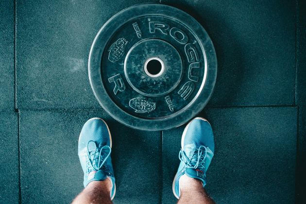 A weight plate at a trainer's feet