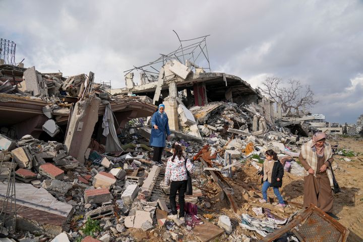 Members of the Dwaima family stand on the rubble of their home, which was leveled by an Israeli airstrike during the Israel-Hamas war, in the Tal al Hawa neighborhood in Gaza City, Monday, Feb. 24, 2025. (AP Photo/Abdel Kareem Hana)