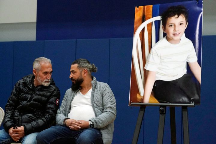 Wadee Alfayoumi's father, Oday Al Fayoume, seated right, and his uncle Mahmoud Yousef attend a vigil for Wadee at Prairie Activity and Recreation center in Plainfield, Ill., Oct. 17, 2023.