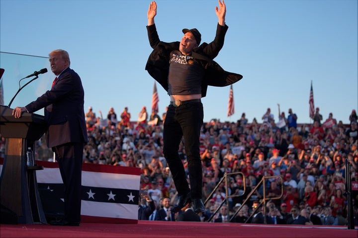 Elon Musk jumps on the stage as Donald Trump speaks during a campaign rally at the Butler Farm Show on Oct. 5, 2024, in Butler, Pennsylvania.