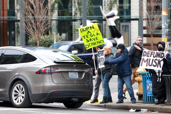 In the last few weeks, there's been #TeslaTakedown pickets outside Tesla showrooms in over 100 cities, including Seattle, pictured here.