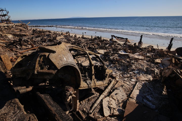 A burned car is among the wreckage of a home destroyed by the Palisades Fire on Jan. 14 in Malibu, Calif.