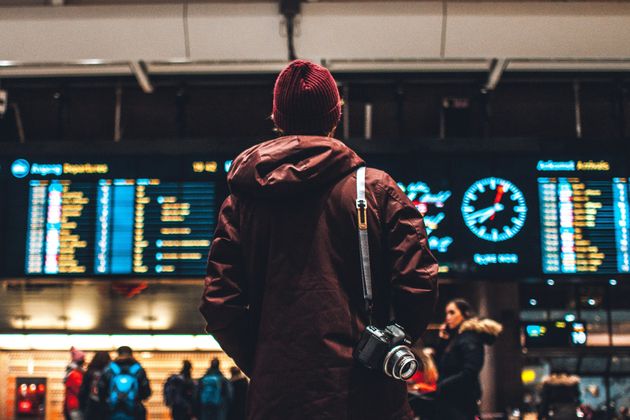 A person looking at departure times on an airport board