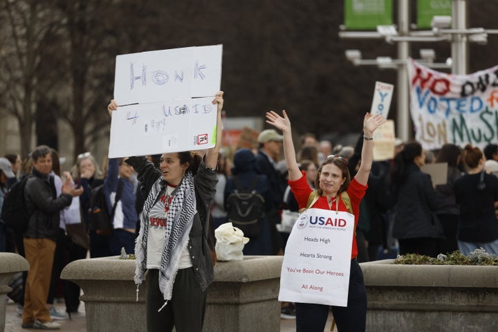 People gather outside the Ronald Reagan Building during a "clap out" in support of United States Agency for International Development staff.