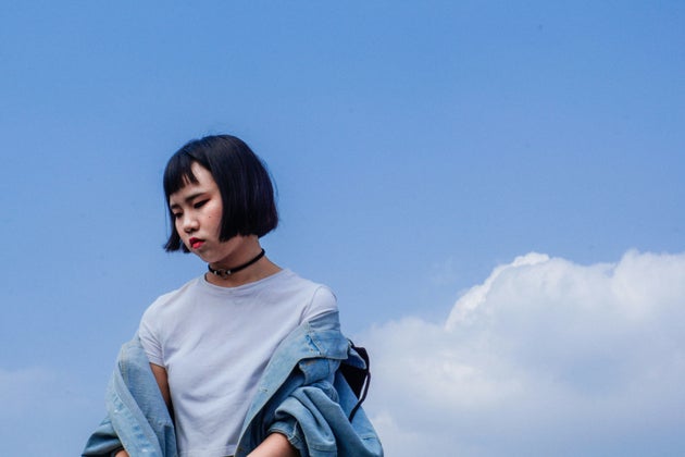 Woman looking sad in front of a blue sky