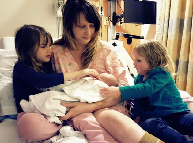 The author introducing her children to their new baby brother