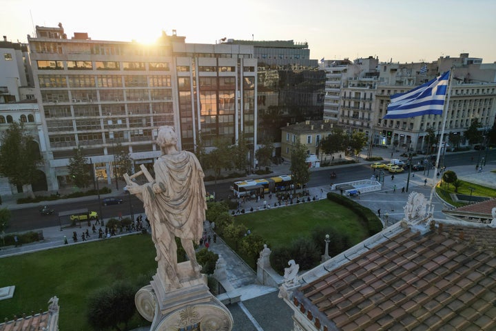 Ο ήλιος δύει μπροστά από το άγαλμα του αρχαίου θεού Απόλλωνα του 19ου αιώνα, πάνω από την Ακαδημία Αθηνών