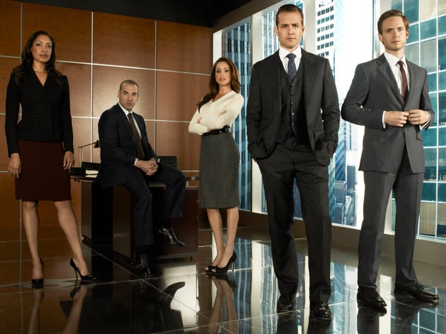 (From left to right) Gina Torres as Jessica Pearson, Rick Hoffmann as Louis Litt, Meghan Markle as Rachel Zane, Gabriel Macht as Harvey Specter, Patrick Adams as Mike Ross on Suits.