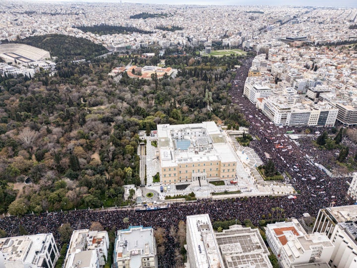 An aerial panoramic view from a drone shows hundreds of thousands of people demonstrating in Athens, Greece, on February 28, 2025, in front of the Hellenic Parliament, Syntagma Square, and all the surrounding roads, occupying kilometers, to mark the second anniversary of a train collision disaster at Tempi, known as the Tempi train crash, which killed 57 people in 2023. Thousands of protesters gather in Athens to demand justice two years after Greece's deadliest train crash. The tragedy, which occurs on February 28, 2023, near Tempi in northern Greece, kills 57 people, including university students and train crew members. In response to the crash's aftermath, workers stage a nationwide strike, halting flights, sea, and land transport, while shops close and theatres cancel performances. Demonstrators express their anger at the perceived lack of accountability for the devastating incident, accusing authorities of a cover-up and demanding the resignation of the current government. The protest is one of the largest ever recorded in the country. (Photo by STR/NurPhoto via Getty Images)