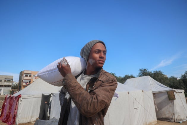 Palestinians queue to receive food aid from an UNRWA distribution center at the Nuseirat refugee camp in the central Gaza Strip on March 3, 2025.