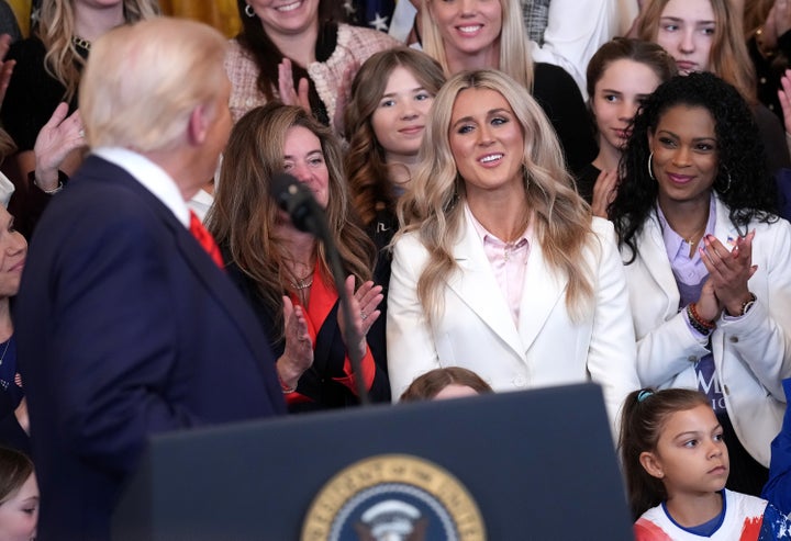 Trump looks back at anti-trans-in-sport activist Riley Gaines on a day he signed an executive order aimed at preventing transgender women from participating in women's athletics.