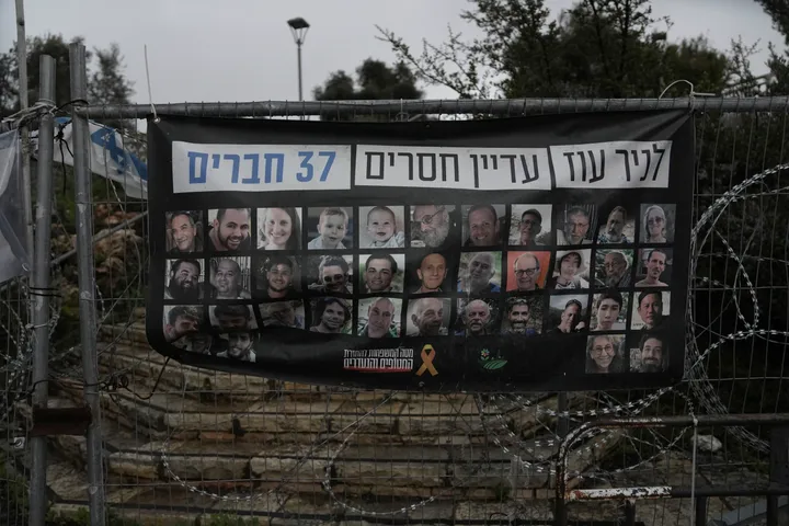 A poster in Jerusalem shows portraits of Bibas family, top row from second left: Yarden, Shiri, and their sons Ariel and Kfir, who were taken hostage on Oct. 7, 2023. Letters on top read, "37 members of Kibbutz Nir Oz are still missing," on Friday, Feb. 21, 2025.