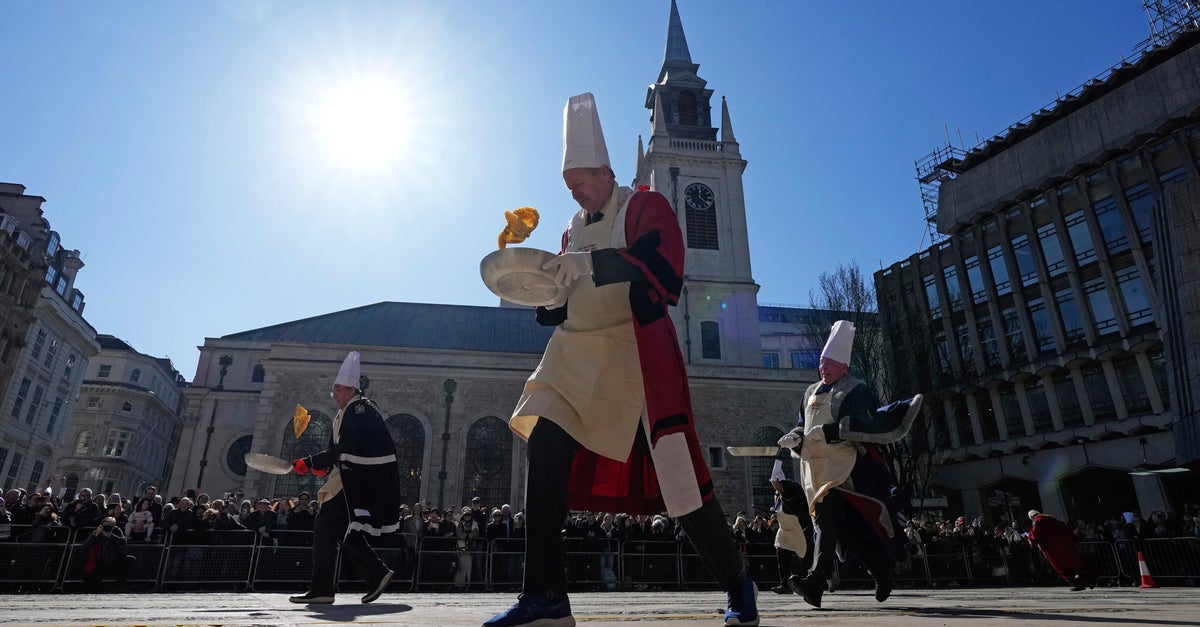 NextImg:Crowds Cheer As Runners With Frying Pans Race To Mark Annual Pancake Day