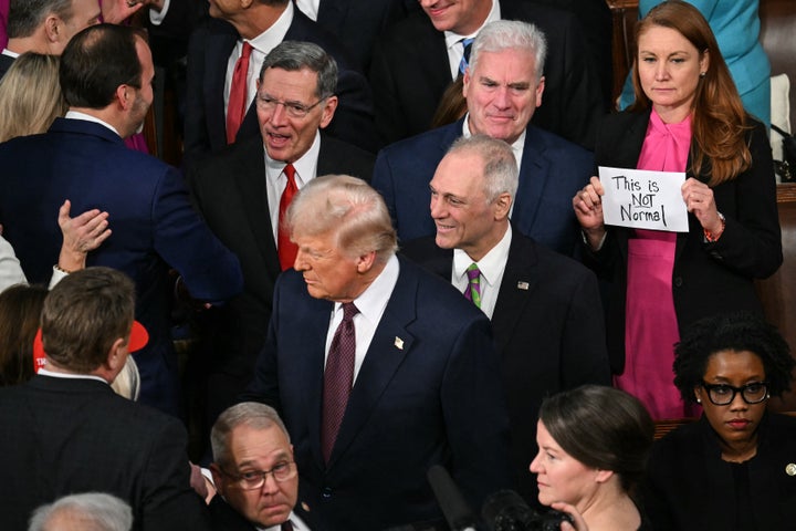 Representative Melanie Stansbury, a Democrat from New Mexico, holds a sign reading "This is not normal" as President Donald Trump arrives to address a joint session of Congress in Washington, D.C., on Tuesday.