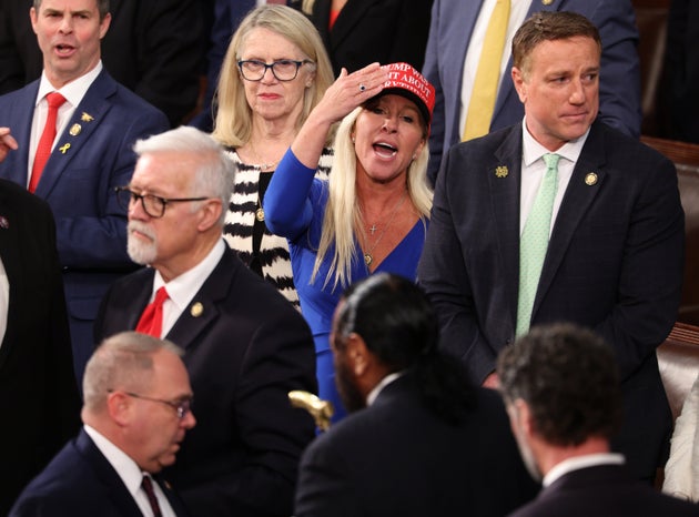 Rep. Marjorie Taylor Greene (R-Ga.) waves her hand as Rep. Al Green (D-Texas) is removed from the chamber.