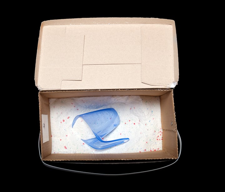 Laundry detergent in an open box isolated on a black background.