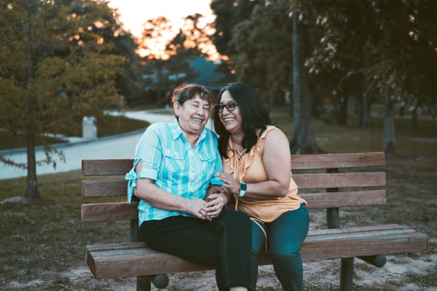 Two women laughing on a bench.